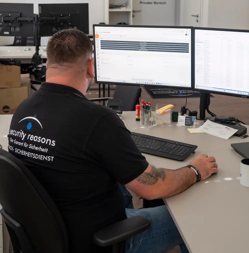 Mitarbeiter von security reasons plant an zwei Bildschirmen die Einsätze