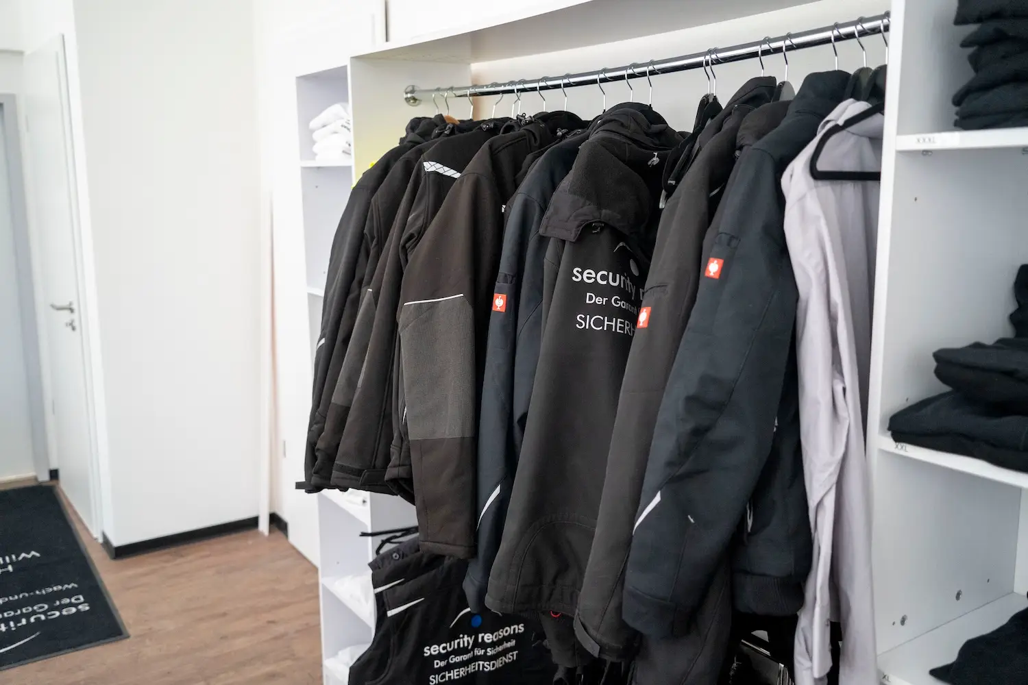 Einsatzjacken von security reasons auf einer Kleiderstange im Umkleideraum