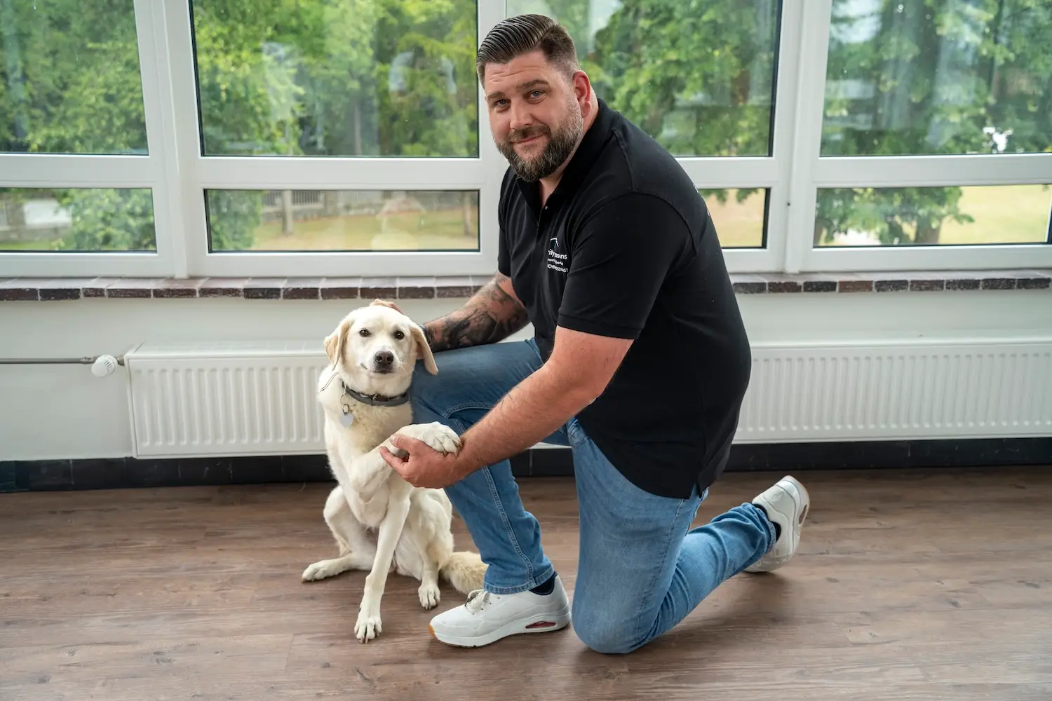 Mitarbeiter von security reasons kniet neben einem hellen Hund